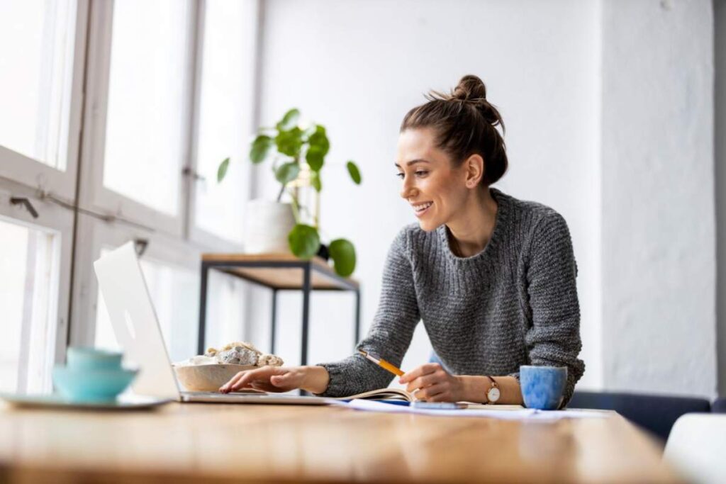 A title insurance professional reviews property documents with a couple at a desk, papers and a computer visible.