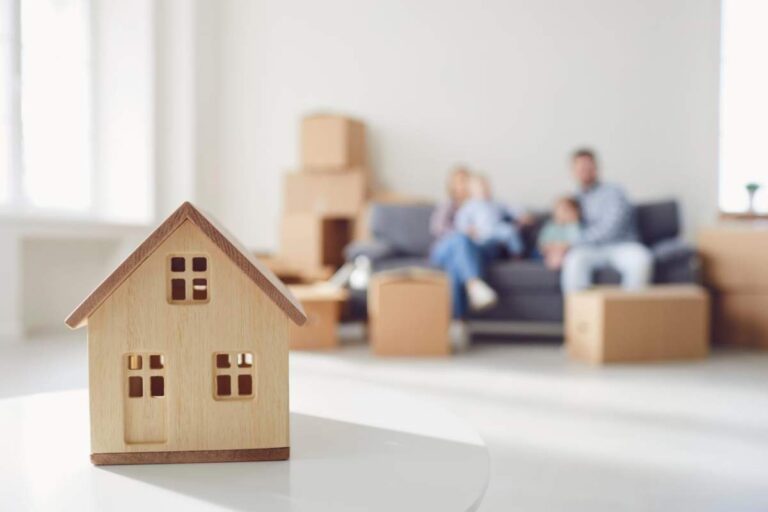 A couple reviews home purchase documents with a title insurance policy at a kitchen table.
