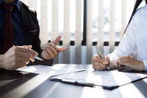 A homebuyer reviews a title report beside property records and closing documents on a table.